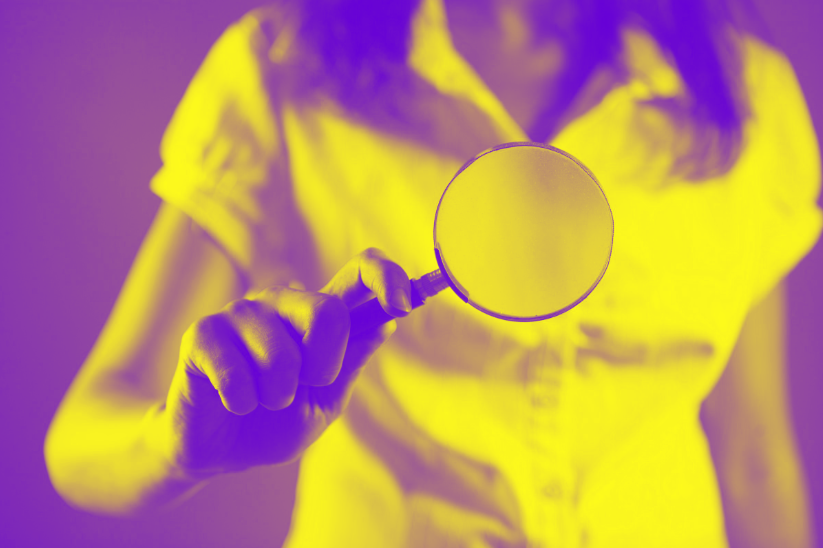woman holding magnifying glass