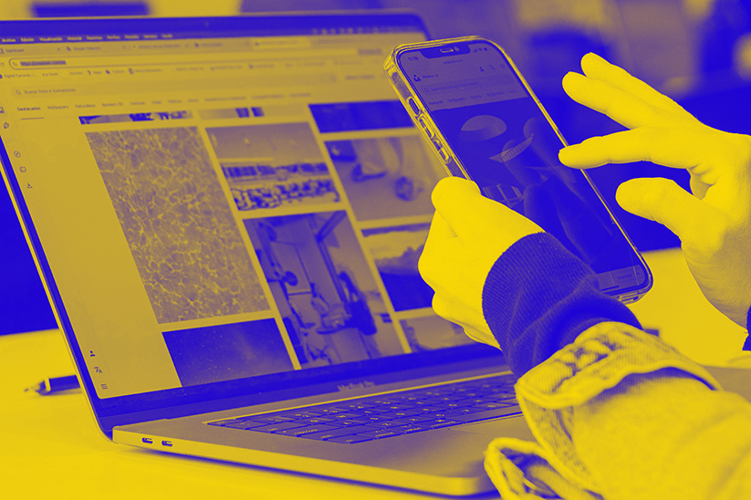 hands in front of laptop screen holding mobile screen
